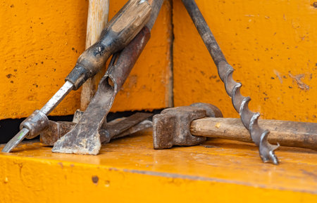 rusty, old, worn out carpenter tools for domestic farming lie on the wooden steps of a private house
