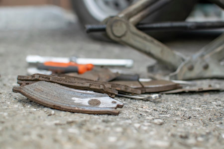 worn out, old, rusty car brake pads, worn to iron, lie on the asphaltの写真素材
