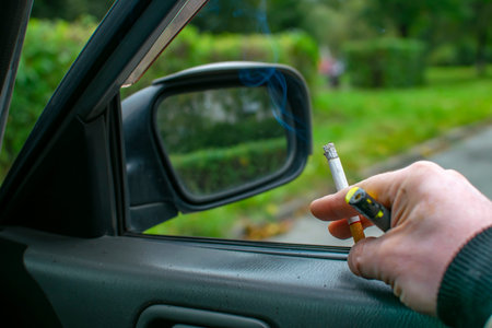 smoking cigarette with a filter in the hand of the driver car
