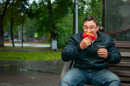 guy with a funny facial expression bites, eats a sweet donutの写真素材