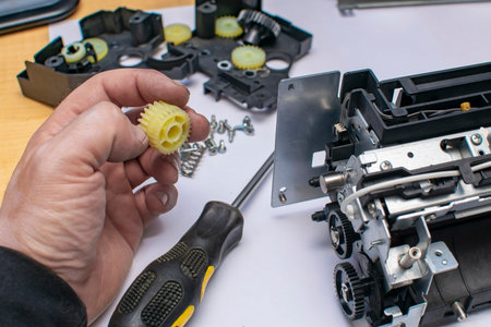 a plastic gear with grease in the hand of a man, a service center master