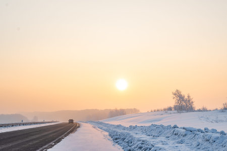 a view of a winter frosty landscape with an asphalt road