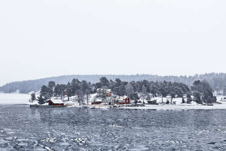Sweden house in the wintertime. Nature on the shore of the fjord.の写真素材
