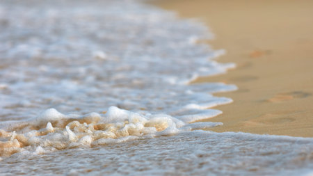 Soft Wave Of Blue Ocean On Sandy Beach. Background. Splash of waves on the sandy beach. foam, surf,...