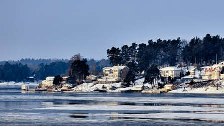 Sweden house in the wintertime. Nature on the shore of the fjord.の写真素材