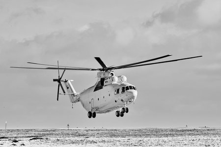 Transport helicopter Mi-26 TC in flight. Heavy helicopter in winter. parking lot (on the...