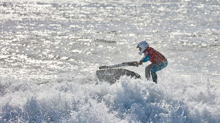 Professional jet ski riders compete at the IFWA World Tour Jet Ski Championship. Contestants perform tricks for judges in the waves. Freeride World Championship IFWA. 27.04.2018, Nazare, Portugalのeditorial素材