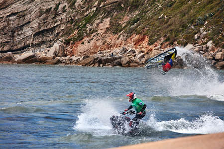 Professional jet ski riders compete at the IFWA World Tour Jet Ski Championship. Contestants perform tricks for judges in the waves. Freeride World Championship IFWA. 27.04.2018, Nazare, Portugalのeditorial素材