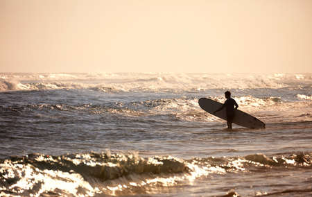 Surfer on the beach. morning on ocean beach. Water sport activity. Atlantic Ocean, Dominican Republic.の写真素材