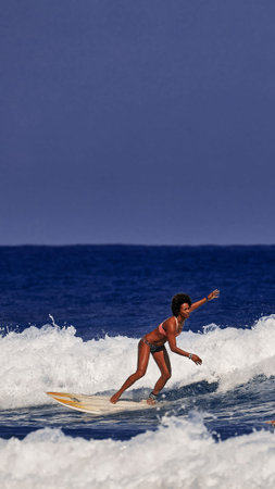 Beautiful young woman is learning to stand on a surfboard. Surf school. Water sports, Atlantic ocean...