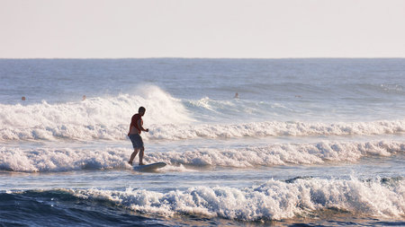 A man learns to stand on a surfboard. Surf school. Water sports, Atlantic ocean Dominican Republic....