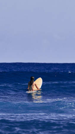 Surfer girl is waiting for a wave. Surfer school. Beautiful young woman Surfer on the wave. beautiful ocean wave. Water sports activities.の写真素材