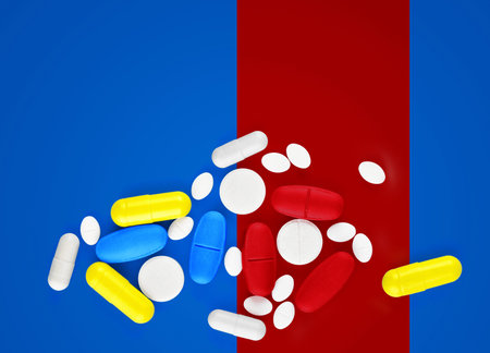 Assorted pharmaceutical medicine pills, tablets and capsules on blue background.