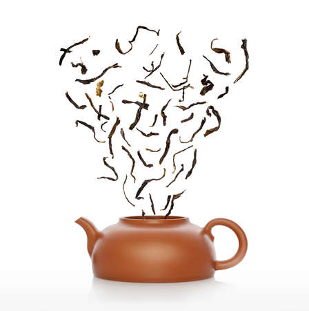 Tea pot and pile of raw chinese tea isolated on white.の写真素材