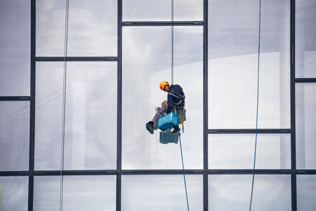 Window Cleaner at Working. Window cleaner, in the suspension system. Industrial mountaineering....