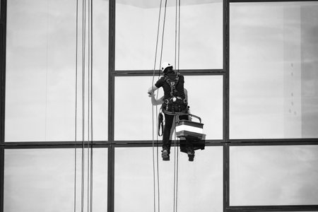 Window cleaners at work. Window cleaner, in the suspension system. Industrial mountaineering.の写真素材