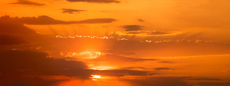 Sunset sky Panorama. Sunset sky, sun and clouds in orange light.の写真素材