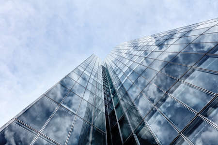 Skyscrapers with clouds reflection. Business building, office buildings. Modern glass silhouettes on modern building.の写真素材
