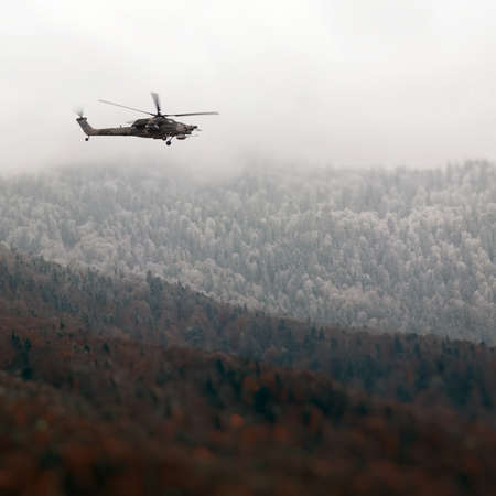 Combat helicopter over the winter mountainsの写真素材