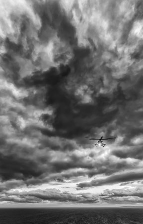 Storm at sea, Mi-8 helicopter from below in front dramatic sky, stormy sky
