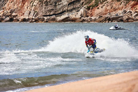 Professional jet ski riders compete at the IFWA World Tour Jet Ski Championship. Contestants perform tricks for judges in the waves. Freeride World Championship IFWA. 04/27/2018, Nazare, Portugalのeditorial素材