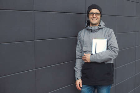 Closeup portrait of handsome 30-35 years old man outdoors standing near the wallの写真素材
