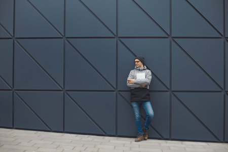 Closeup portrait of handsome 30-35 years old man outdoors standing near the wallの写真素材