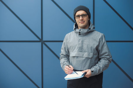 Closeup portrait of handsome 30-35 years old man outdoors standing near the wallの写真素材