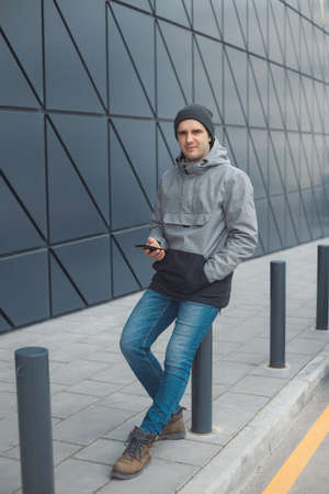 Street style portrait of handsome 30-35 years old man outdoors near the wallの写真素材