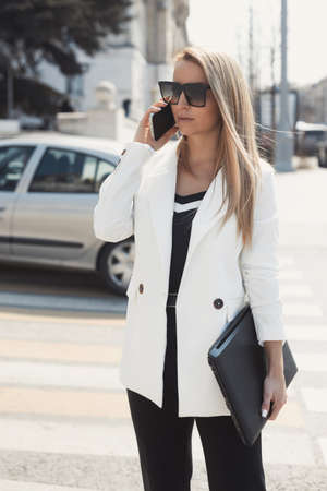 Street style portrait of serious business woman with laptopの写真素材