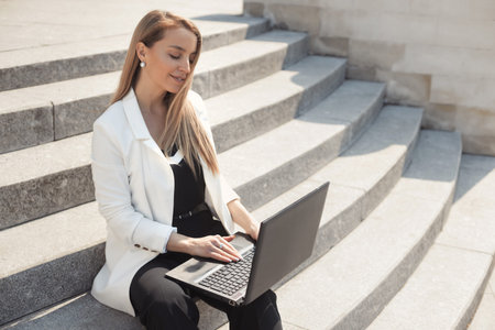 Street style portrait of serious business woman with laptopの写真素材
