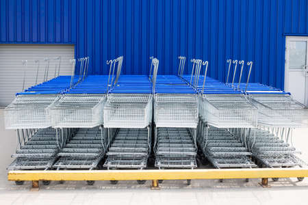 Many empty metal carts for shopping in a supermarket parking. Store closed at lockdown due to coronavirus pandemicの写真素材