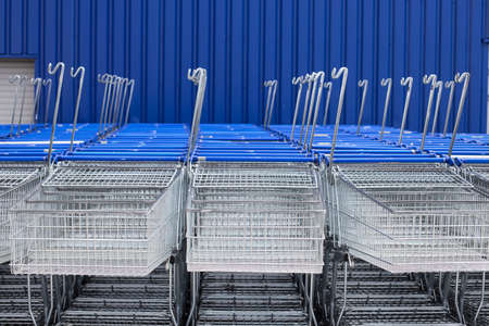 Many empty metal carts for shopping in a supermarket parking. Store closed at lockdown due to coronavirus pandemicの写真素材