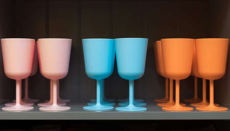 Colorful wine glasses in pink, blue and orange colors. Multicolored dishes in the kitchen barの写真素材