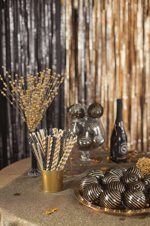 Festive decorations on table setting in black and gold colors to celebrate the new year and christmas partyの写真素材