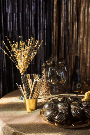 Festive decorations on table setting in black and gold colors to celebrate the new year and christmas partyの写真素材