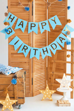 Childrens room photo zone in blue colors for a little boy for a birthday party celebration. Cute eco-friendly childrens place from natural materials and a Happy Birthday garlandの写真素材