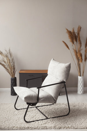 Comfortable easy chair in a modern trendy home interior in pastel natural colorsの写真素材