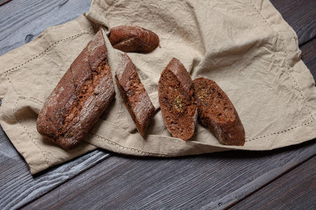 Freshly baked homemade rye bread with herbs and garlic butter.  On a dark brown wooden background. Rustic style. Place for text. Top viewの写真素材
