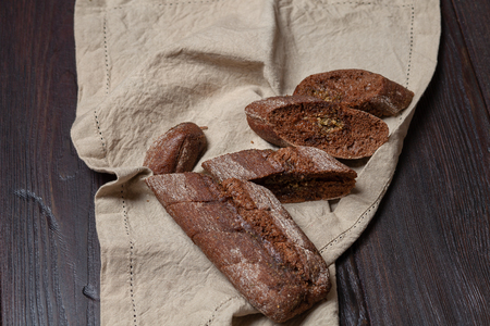 Freshly baked homemade rye bread with herbs and garlic butter.  On a dark brown wooden background. Rustic style. Place for text. Top viewの写真素材