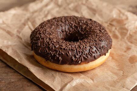 One chocolate doughnut on parchment. Homemade sweetsの写真素材