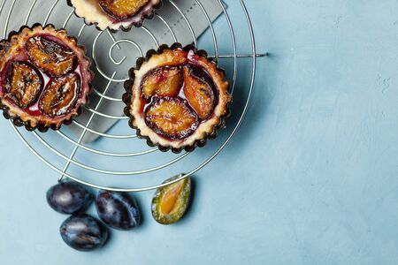 Baking with plums on a blue concrete background. Confectionery productsの写真素材