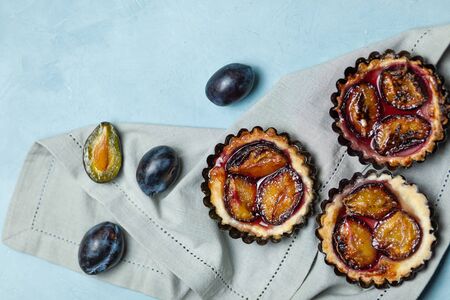 Baking with plums on a blue concrete background. Confectionery productsの写真素材