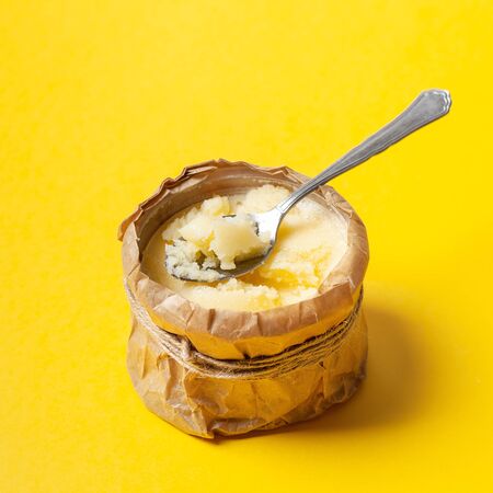 Homemade ghee in a jar with a spoon, wrapped in parchment paper. Ayurvedaの写真素材