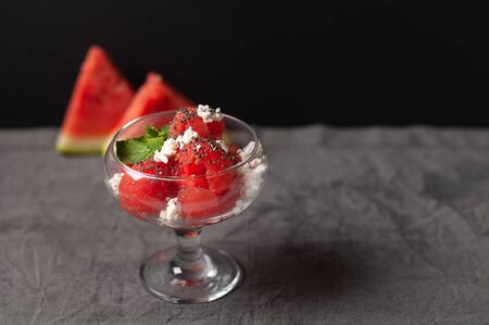 A delicious dessert of watermelon and cream cheese, decorated with a leaf of mint and chia seeds. In a glass dishの写真素材