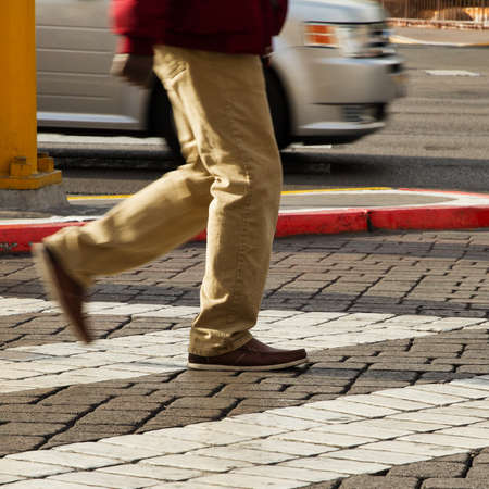Cropped image of man crossing the road, blur motion, focus on right shoe, Las Vegas, Nevadaの写真素材