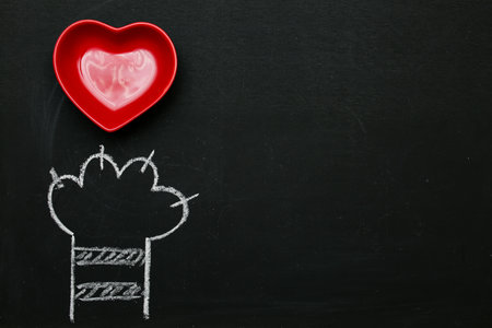 Cats paw red heart drawn in white on a black chalkboard. Background wallpaper for Valentines day greeting card.の写真素材