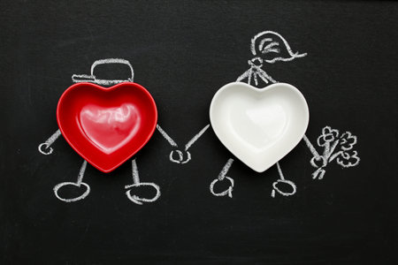 two hearts red and white lovers hold hands, drawn people congratulation gives flowers. Chalk drawing...