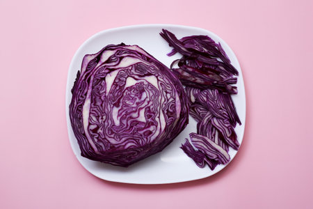 Red cabbage is cut in half. On a pink background.の写真素材