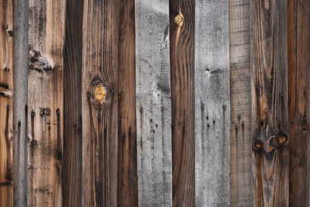 Wood texture wallpaper background, vintage darkened fence. Gray and brown boards with rusty nails.の写真素材